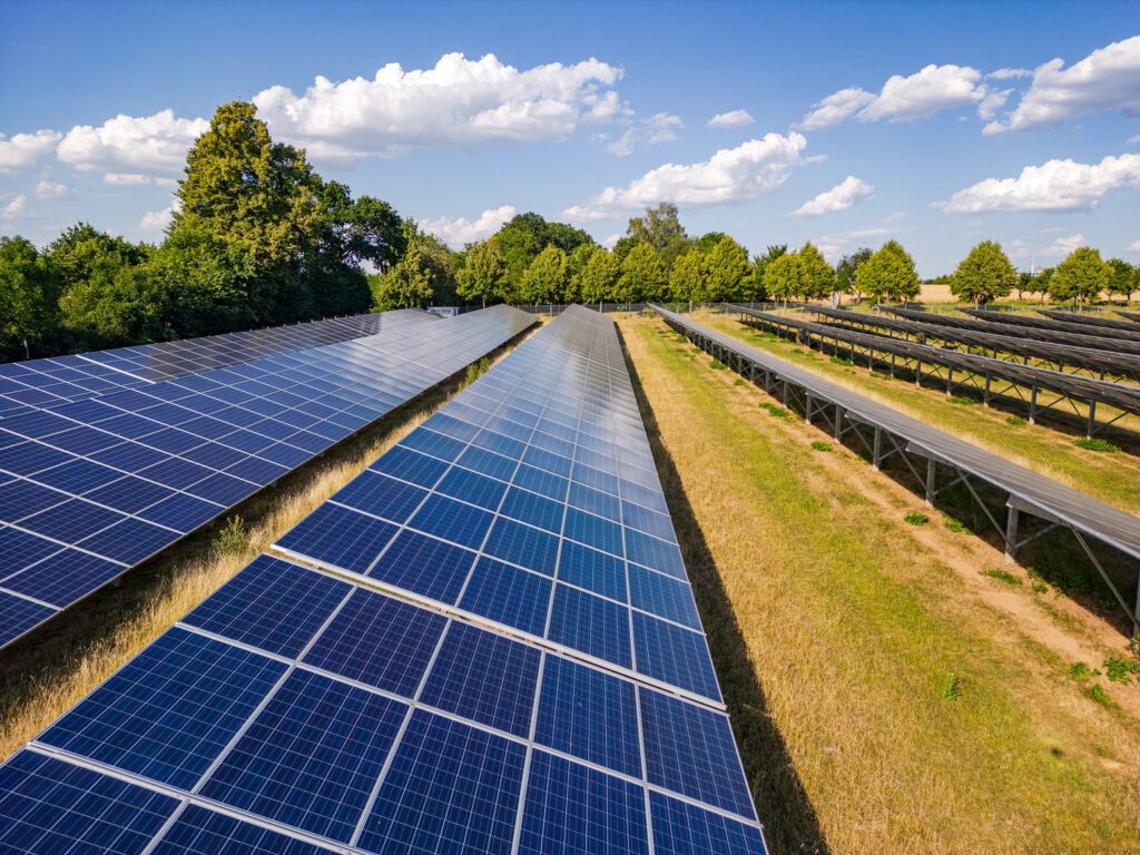 Aerial view of a solar farm generating solar power over many rows of solar panels